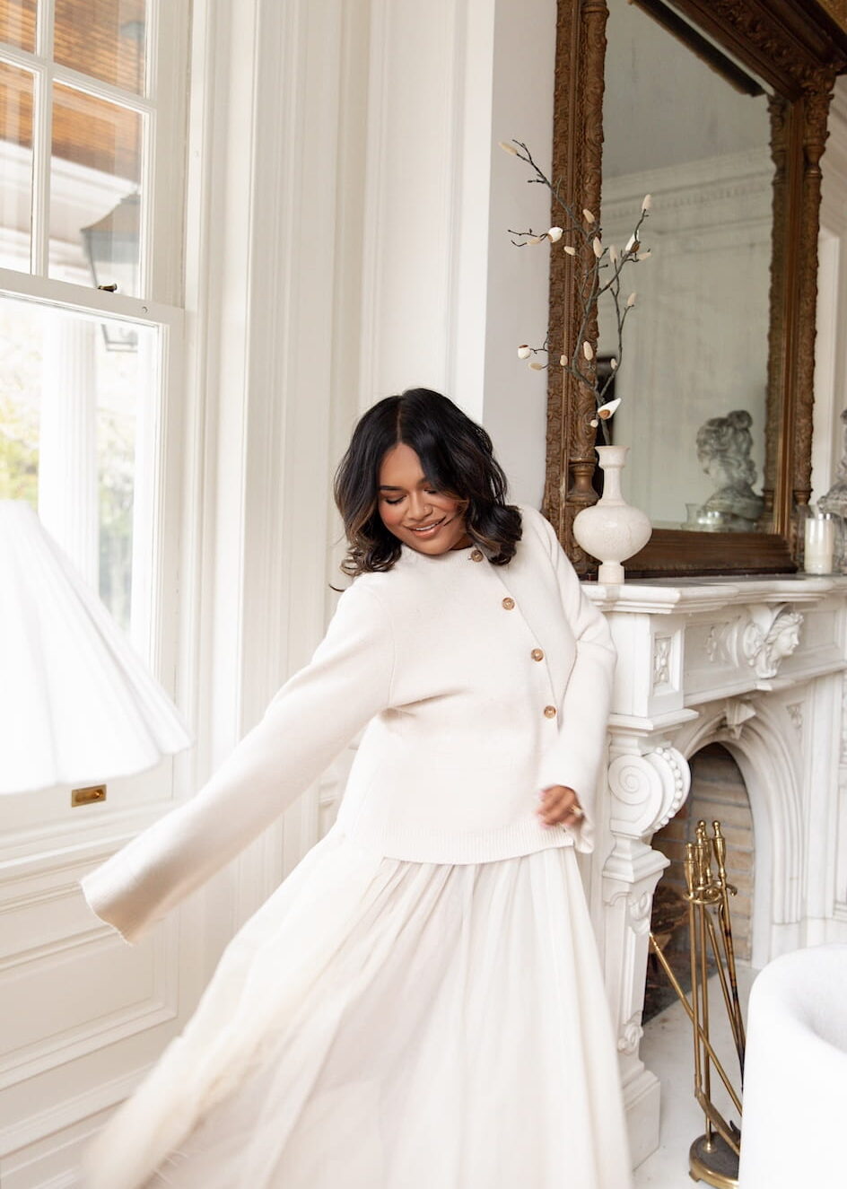 Nabela Noor in a light-filled Georgian Revival home, wearing a soft neutral outfit and embodying her “pockets of peace” philosophy