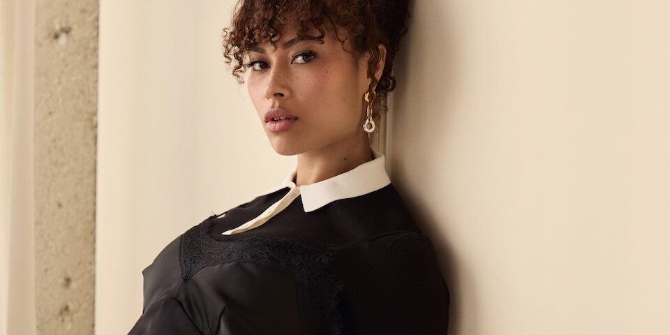 Rainbow Wedell actress interview portrait wearing black dress against neutral background