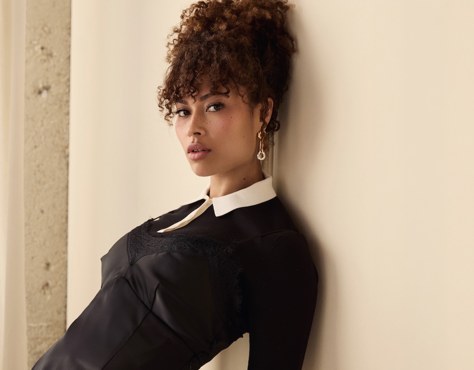 Rainbow Wedell actress interview portrait wearing black dress against neutral background