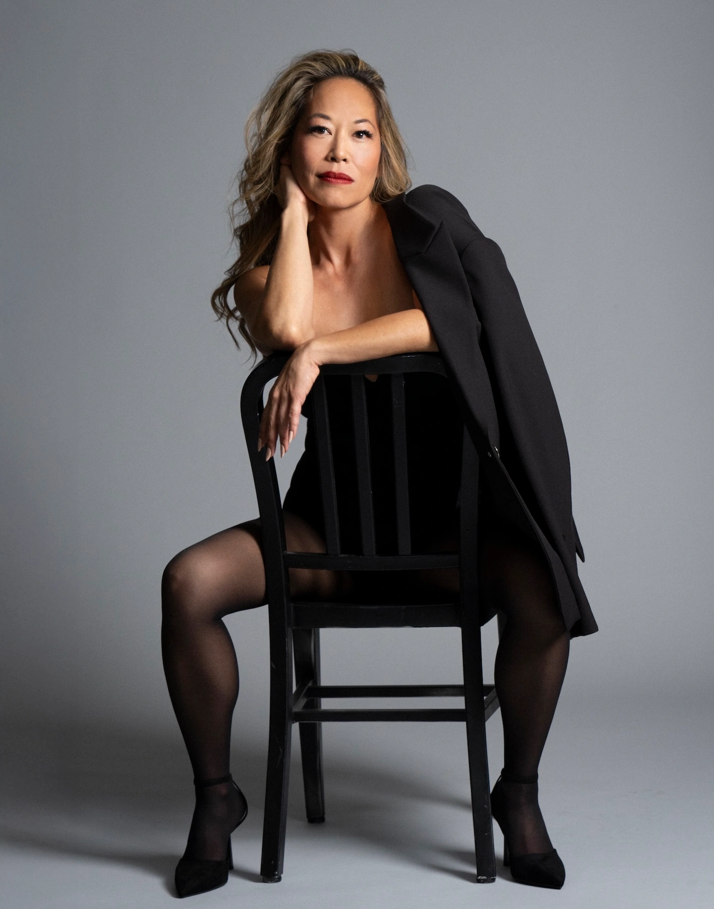 Ailsa Chang seated on chair in black outfit photographed by Elisabeth Caren