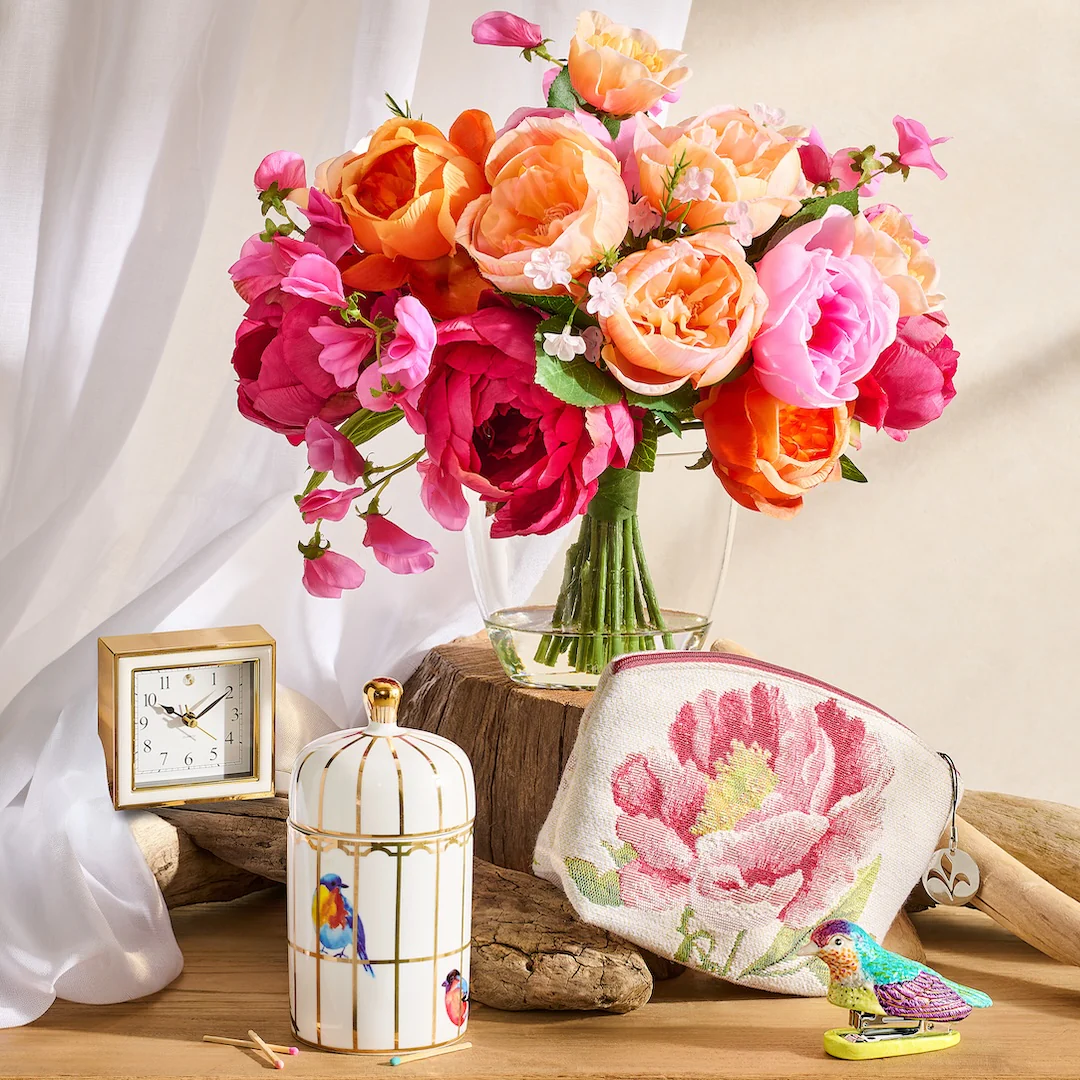 Gilded birdcage candle with floral arrangement and decorative home accents
